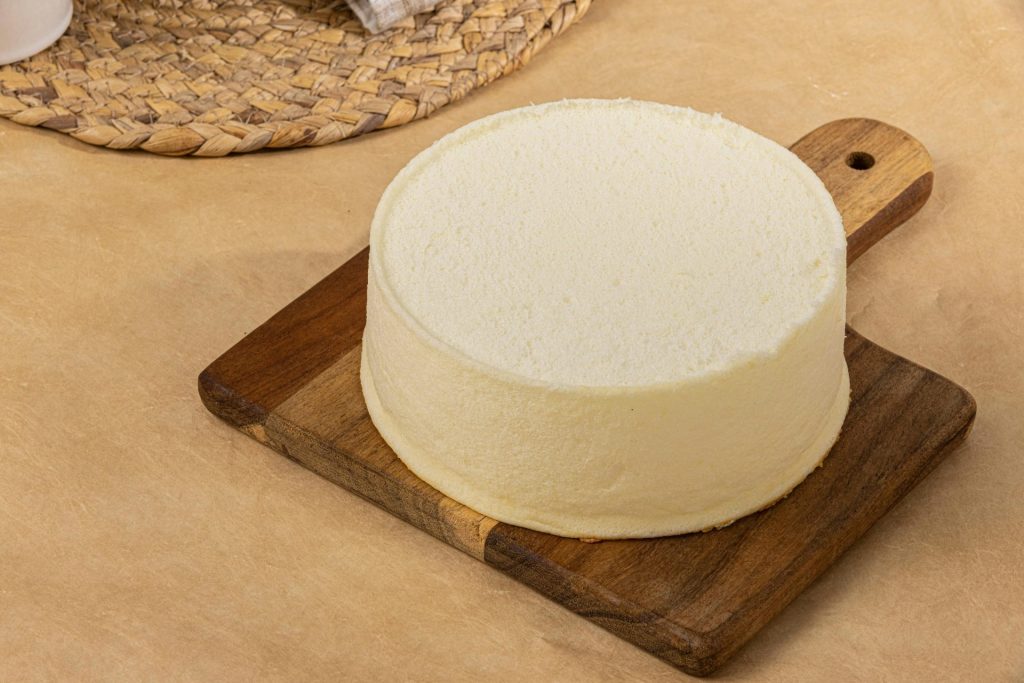 A round cake sitting on top of a wooden cutting board