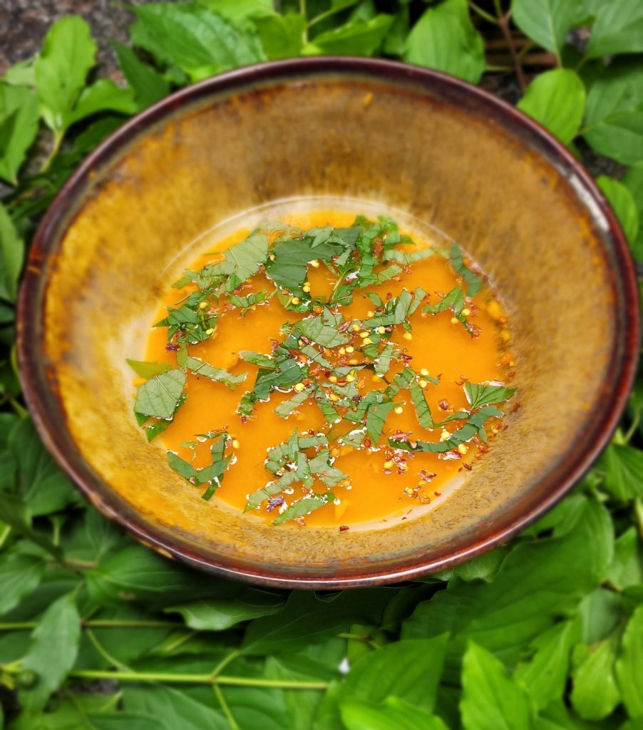A bowl of soup is sitting in the grass